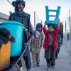 A displaced family carrying their belongings in Kandahar, Afghanistan.