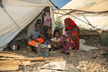 A family from Eritrea sit outside their shelter at a refugee site in the Amhara region of Ethiopia.