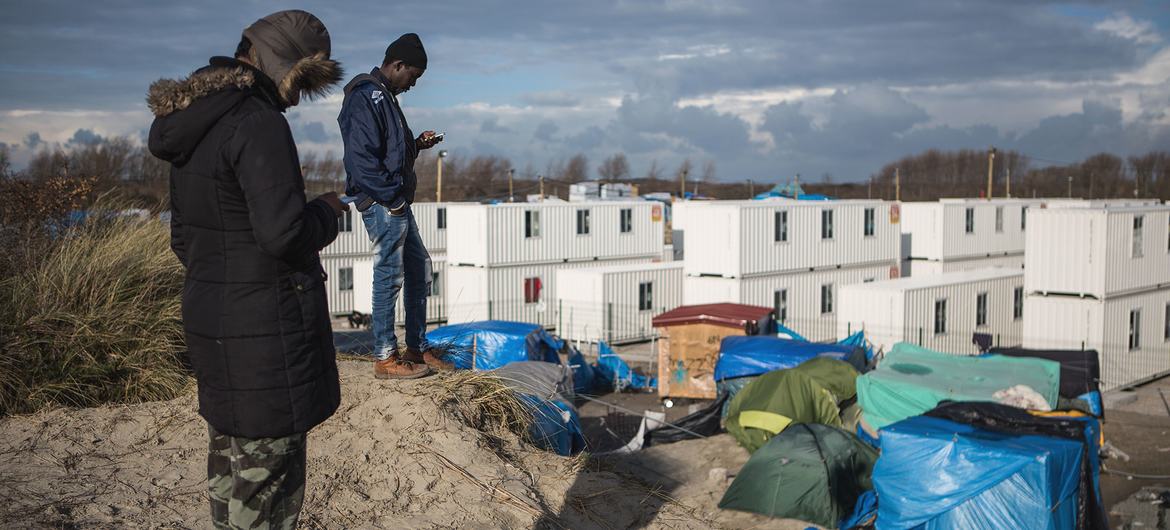 مهاجران منتظرند تا از محل اقامت مهاجران در کاله در شمال فرانسه به انگلستان برسند.  (فایل)