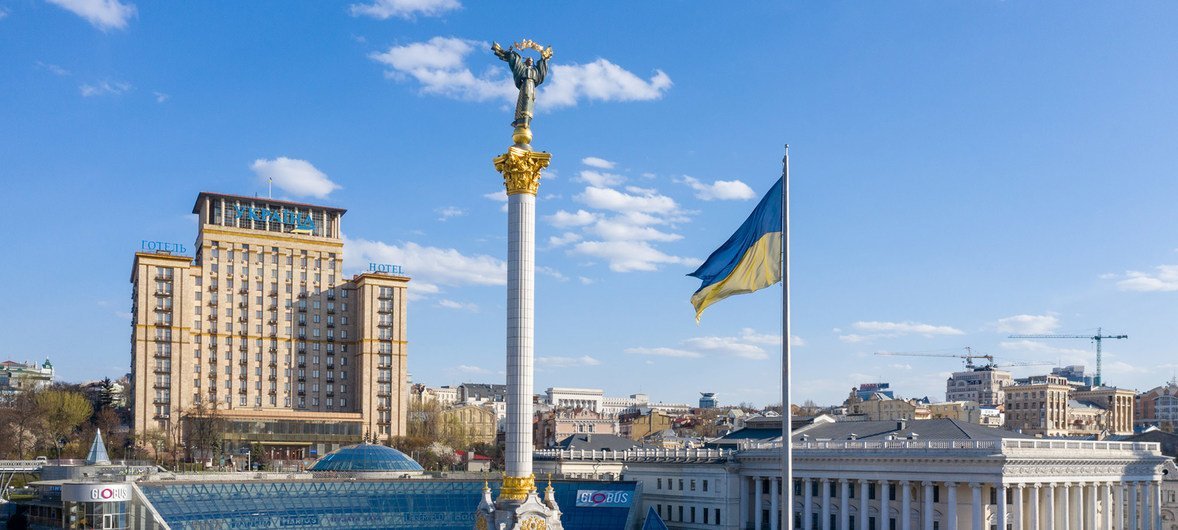 Памятник Независимости в Киеве, Украина, с развевающимся украинским флагом. Площадь пустует из-за мер социального дистанцирования, введенных в связи с COVID-19.