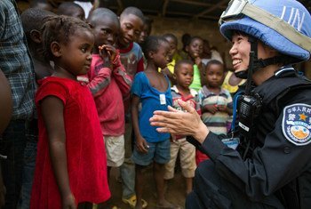 Офицер полиции Китая, служащая в составе миротворческого контингента ООН в Либерии - с местными детьми
