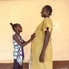 Mwanamke mjamzito na bintiye wakisubiri nje ya wodi ya akina mama inayoungwa mkono na UNICEF nchini Sudan Kusini.