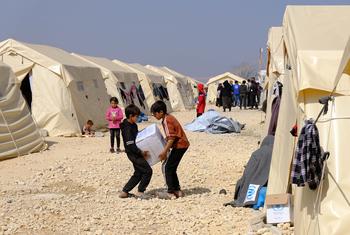 سوريون يتلقون مساعدات في أحد مخيمات النازحين.