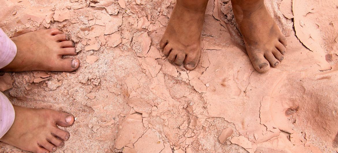 Two children stand barefoot on cracked, parched soil in a dry riverbed in southern Bolivia. (file)