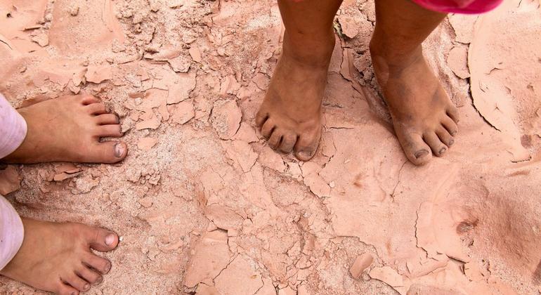 Two children stand barefoot on cracked, parched soil in a dry riverbed in southern Bolivia. (file)