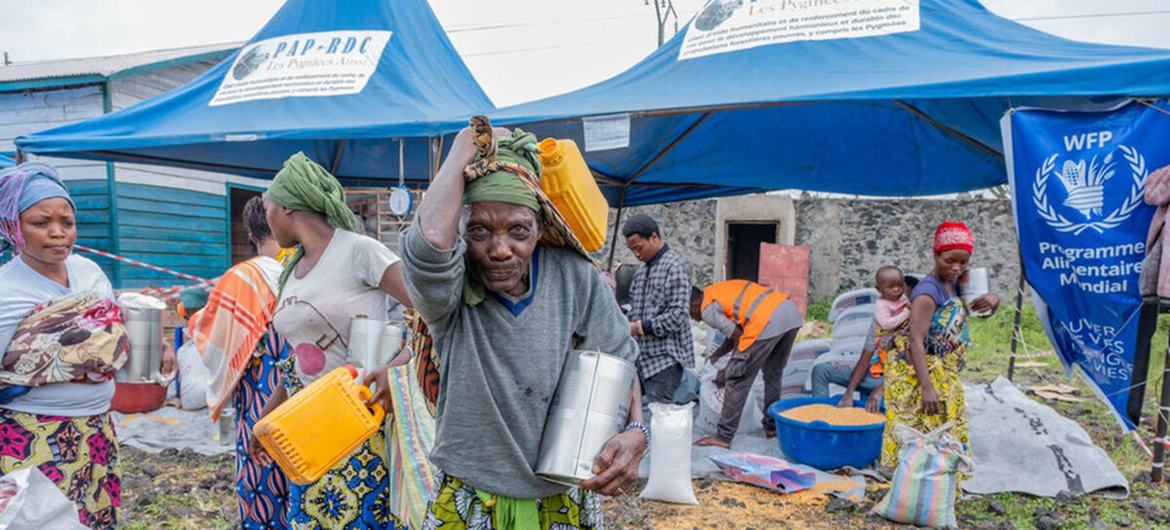 Assistência alimentar a deslocados internos durante uma distribuição de alimentos do PMA num campo para deslocados perto de Goma, em dezembro