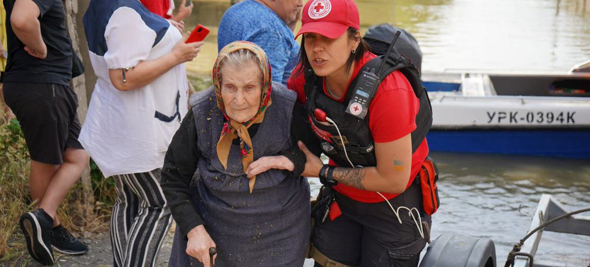 An elderly woman is evacuated from a flooded neighbourhood following the destruction of the Kakhovka dam in southern Ukraine.