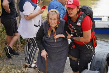 An elderly woman is evacuated from a flooded neighbourhood following the destruction of the Kakhovka dam in southern Ukraine.