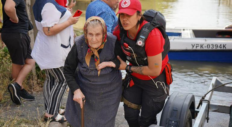 Idosa é evacuada de um bairro inundado após a destruição da barragem de Kakhovka, no sul da Ucrânia.