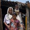 A Rohingya family stand outside their home in a refugee camp in Teknaf, Bangladesh.