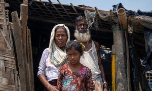 A Rohingya family stand outside their home in a refugee camp in Teknaf, Bangladesh.