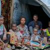 Ombeni, su marido y sus hijos se reúnen fuera de su refugio improvisado en un lugar de desplazados al oeste de Goma tras huir de la violencia.