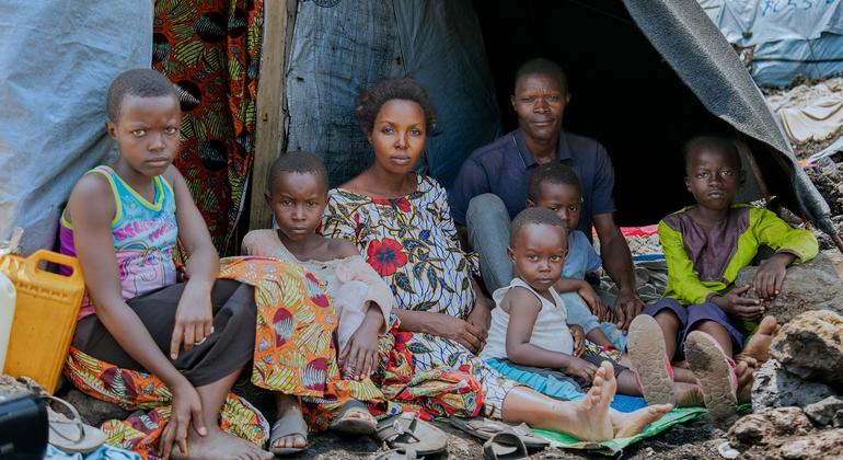Ombeni, su marido y sus hijos se reúnen fuera de su refugio improvisado en un lugar de desplazados al oeste de Goma tras huir de la violencia.