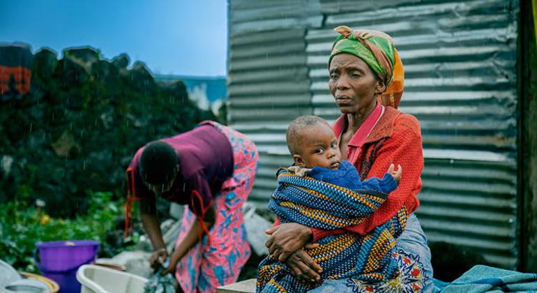 Thérèse holds her grandson in the courtyard of the family home in Goma. With another grandchild due soon, she worries about how she will manage to care for the family.