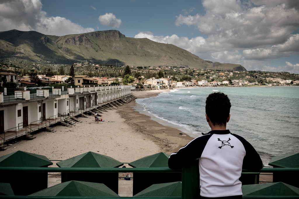 Un joven migrante observando una bahía en Italia (Foto de archivo).