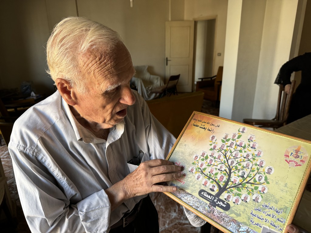 Mahmoud Al-Said holds a plaque of honor specially made for him and other UNRWA teachers. 