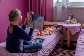 一名来自乌克兰的小女孩和家人在波兰卡佩兰卡一家旅社中临时安顿下来，她正在房间里独自玩耍。