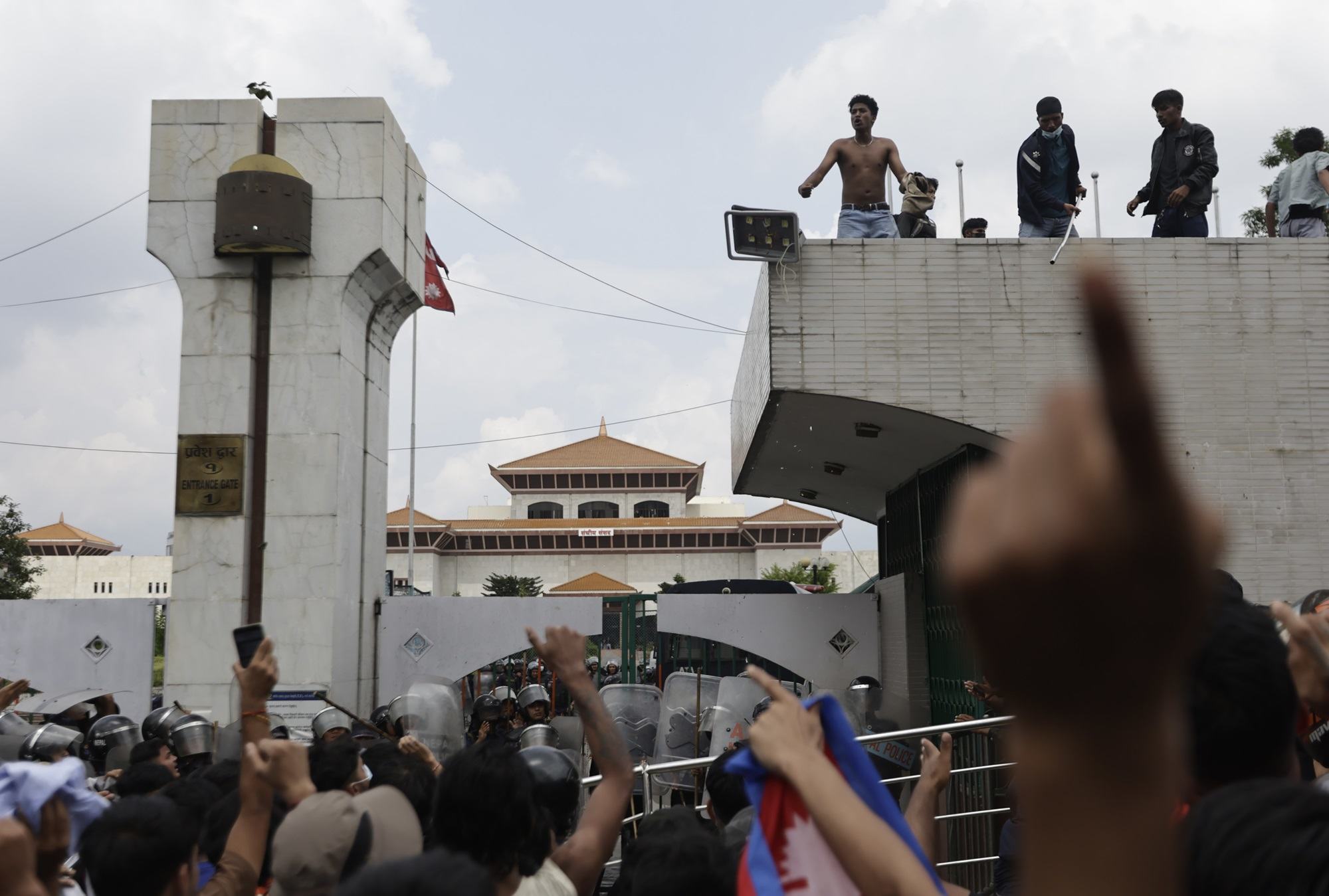 Some protesters climb atop the gates of Nepal's Parliament in Kathmandu on Monday, in youth-led demonstrations against corruption. Some protesters climb atop the gates of Nepal's Parliament in Kathmandu on Monday, in youth-led demonstrations against corruption.