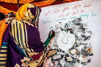 Women play a central role in building and sustaining peace. Pictured here, a woman signs a pledge to bring stability, opportunity and peace to her communities in Darfur. (file)