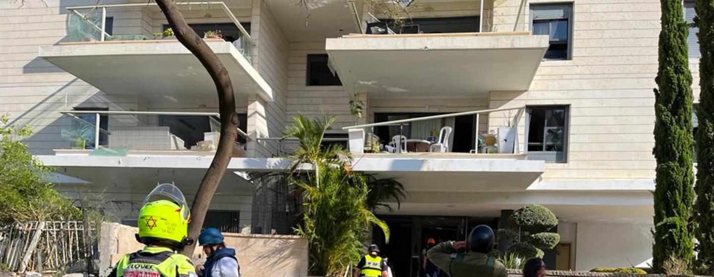 Des secouristes devant un bâtiment résidentiel endommagé dans le sud d'Israël.