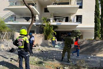 Des secouristes devant un bâtiment résidentiel endommagé dans le sud d'Israël.