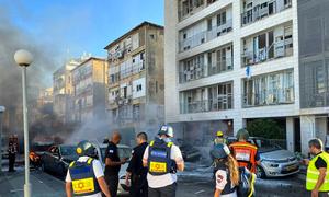 In southern Israel rescue workers stand in a street which has suffered significant damage (file).