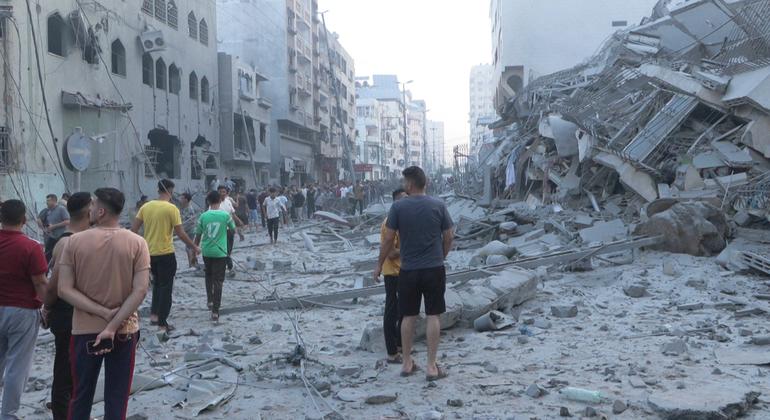 Homens caminham por uma área altamente danificada no centro de Gaza