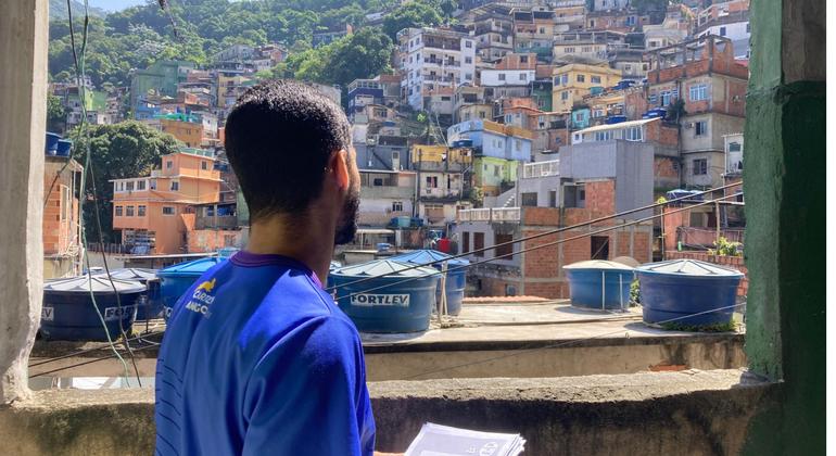 Funcionário do Carteiro Amigo observa a vista de uma favela no Rio de Janeiro Funcionário do Carteiro Amigo observa a vista de uma favela no Rio de Janeiro