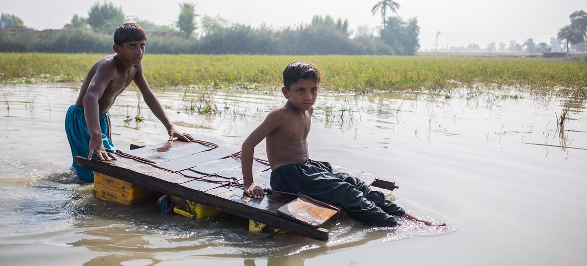 Children make their way home through contaminated floodwater in Jacobabad, Sindh province, Pakistan.