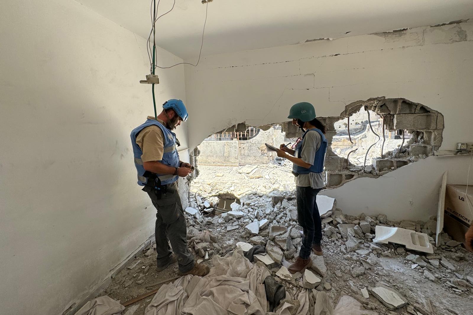 اثنان من موظفي UNMAS يتفقدان مركزًا صحيًا متضررًا في مدينة غزة في 30 يوليو 2024.