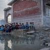 Des enfants sont assis à côté d'un étang d'eau de crue contaminée dans la province du Sindh, au Pakistan.