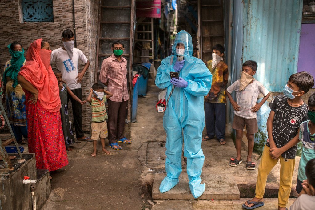 Muhammad Yunus, usando EPI, discursa para membros da comunidade em uma favela de Mumbai sobre precauções contra a COVID-19 durante um programa de conscientização da Unicef .