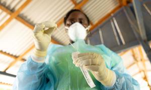 A health worker in Suriname prepares to administer a rapid COVID-19 test.