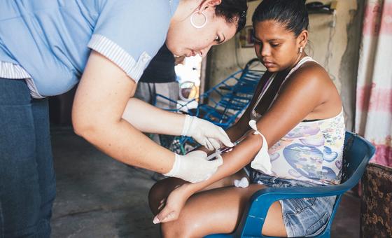 Uma profissional de saúde coleta amostras de sangue de uma mulher que já havia contraído dengue (arquivo)