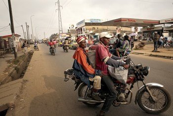 Una mujer carga sus sacos de productos en un mototaxi para regresar a su casa en Camerún.