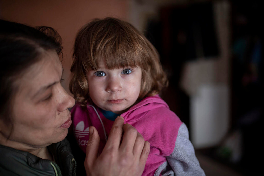 Une mère tient son enfant dans leur appartement, dans un immeuble partiellement détruit dans l'est de l'Ukraine.