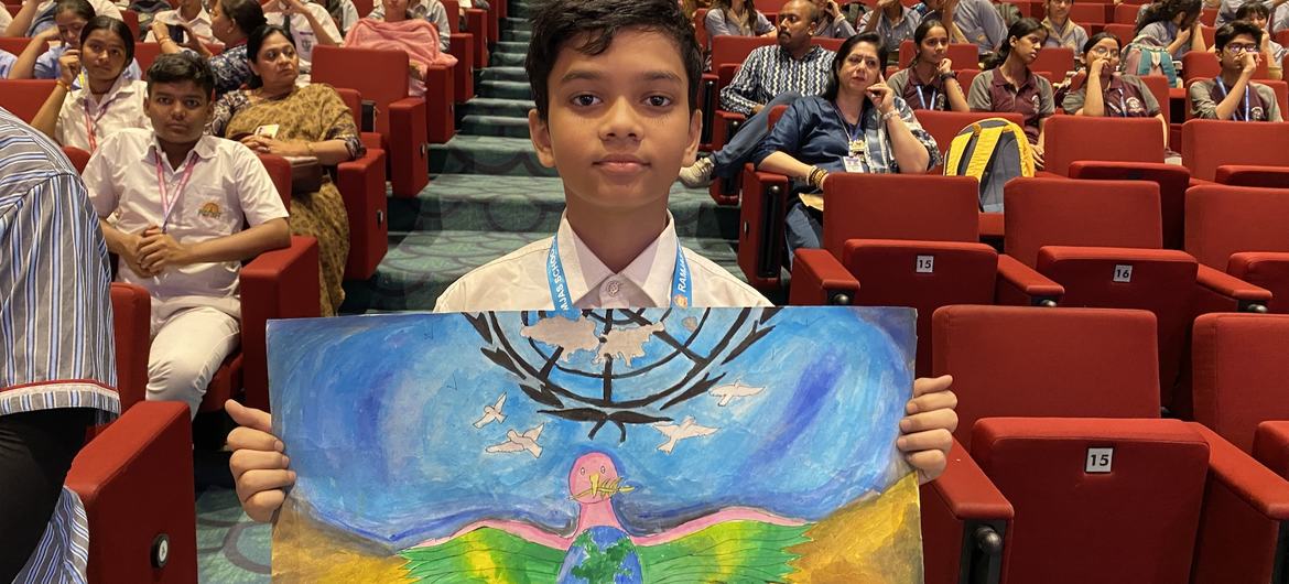 रवांडा के तुत्सी समुदाय के विरुद्ध जनसंहार के पीड़ितों की स्मृति में दिल्ली में आयोजित एक समारोह में अपना बनाया चित्र दिखाता एक बच्चा.