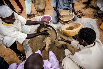 رجال يعدون الدقيق المصنوع من المنتجات المحلية في قرية في تانوت ، النيجر.