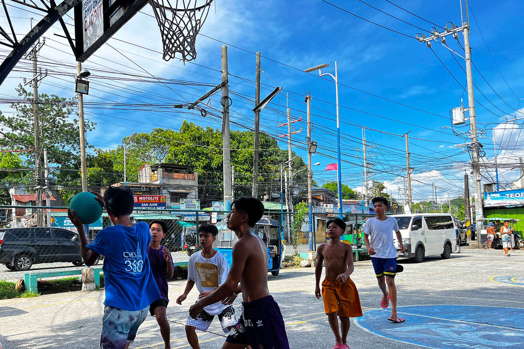 Des jeunes hommes jouent au basket-ball à Antipolo City.