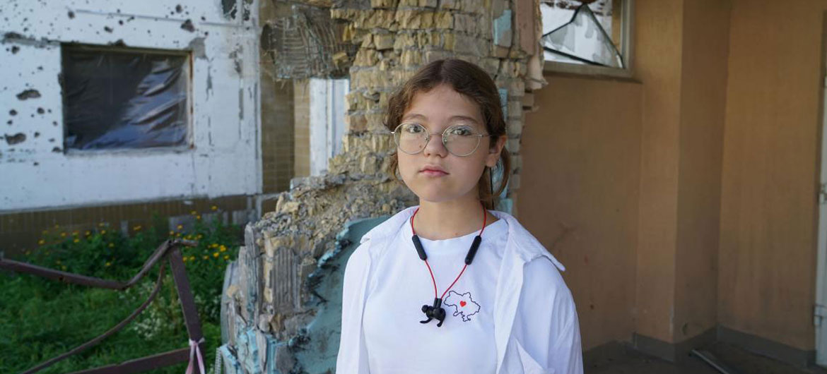 11-year-old Katya stands on the territory of the Irpin school, which was heavily bombed in March 2022.