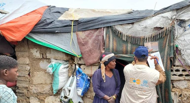 سيدة نازحة بسبب السيول المفاجئة في آب/أغسطس تتحدث إلى موظفي صندوق الأمم المتحدة للسكان خارج المأوى المؤقت الذي تقيم فيه في مأرب، اليمن.