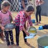 Meninas recebem comida em uma cozinha comunitária em Deir al Balah, Gaza