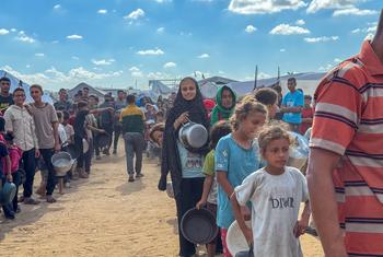 Les Gazaouis font la queue pour obtenir de la nourriture dans une cuisine communautaire à Deir al Balah.