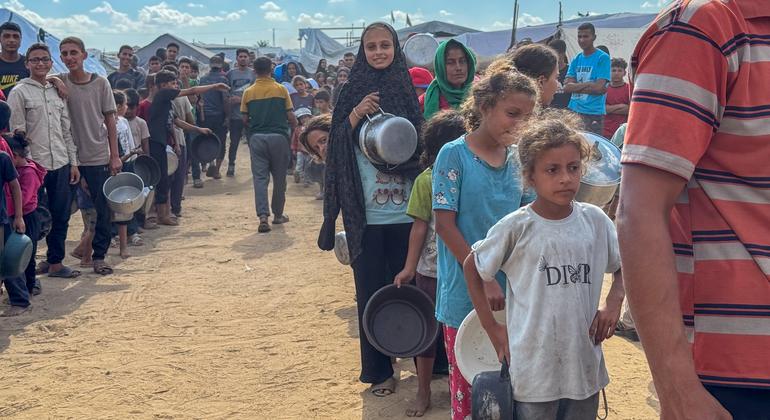 Les Gazaouis font la queue pour obtenir de la nourriture dans une cuisine communautaire à Deir al Balah.