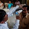 Un médico examina el ojo de un hombre con una lámpara de hendidura durante una prueba de detección de tracoma en la India.