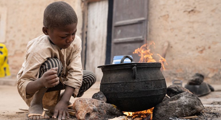 Un enfant aide sa màre à préparer le petit déjeuner au Niger