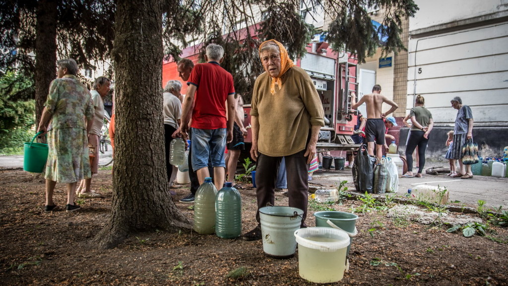 Une femme récupère de l'eau d'un camion à Lysychansk, en Ukraine.