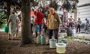 A woman collects water from a truck in Lysychanskt, Ukraine.