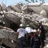 Equipes de resgate procuram em um prédio das Nações Unidas destruído pelo terremoto que atingiu o Haiti em 12 de janeiro de 2010.