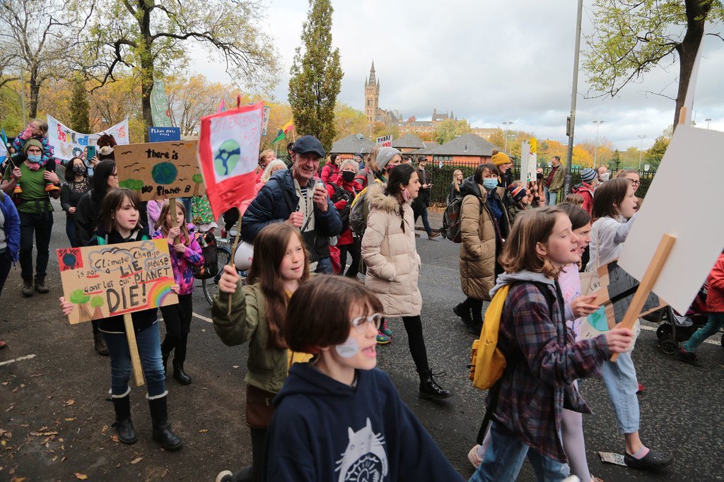 À Glasgow, en Écosse, des personnes participent à une manifestation en faveur de l'action climatique, menée par de jeunes militants pour le climat et organisée en marge de la Conférence des Nations Unies sur le changement climatique de 2021 (COP26).